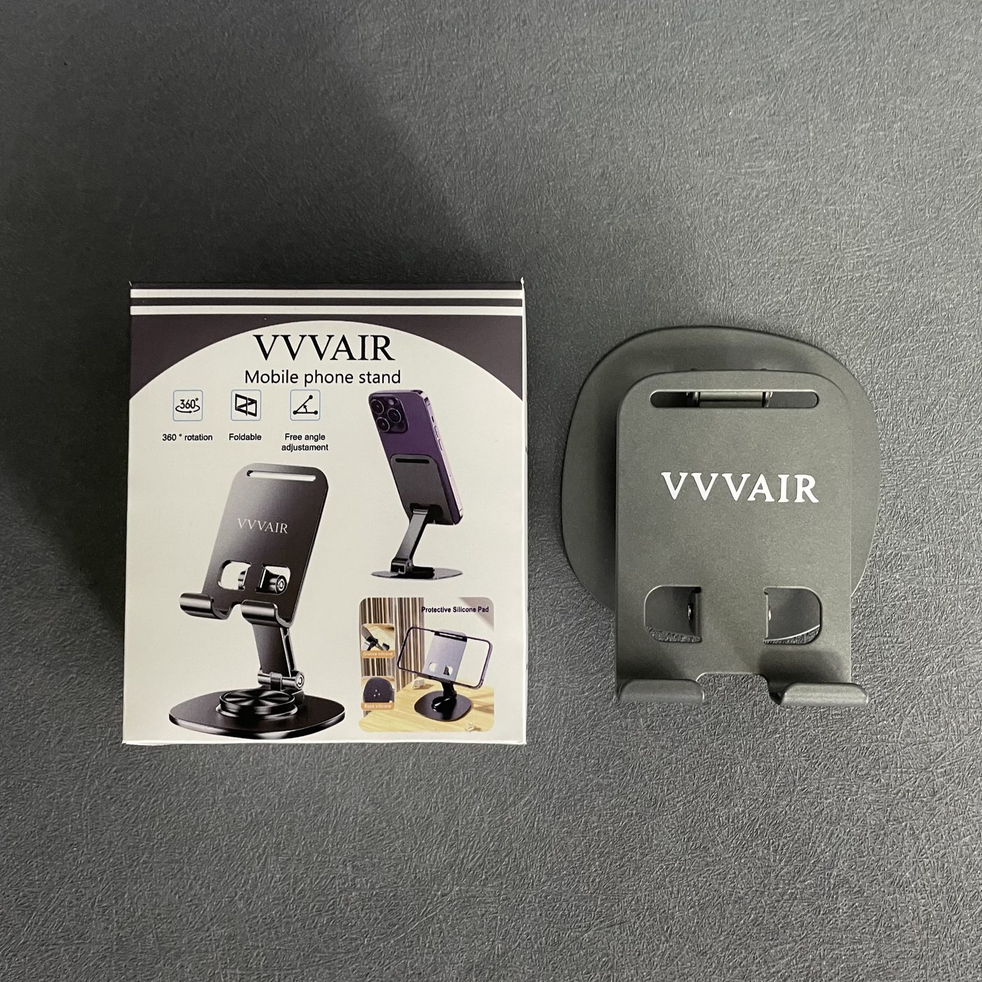 A low-angle view of the packaging box with its spine visible, beside the Space Gray stand